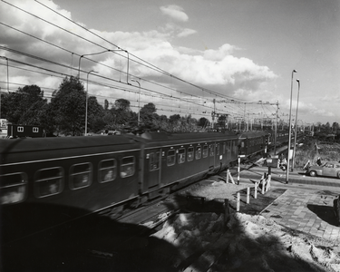 168398 Gezicht op de spoorwegovergang in de Eykmanlaan te Utrecht, tijdens het passeren van een trein.